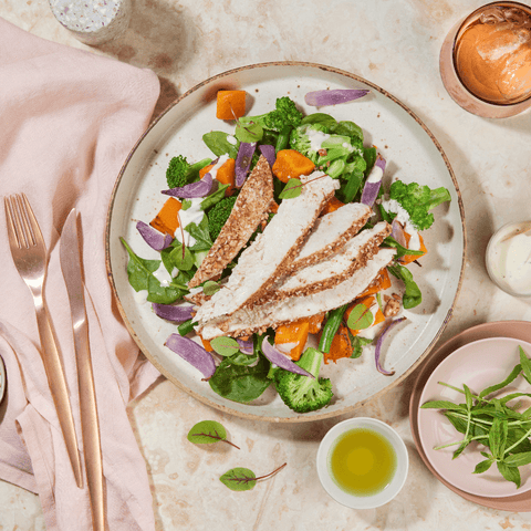 Overhead shot of Dukkah Chicken Salad with cutlery and glass of water